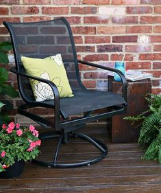 a patio chair sitting on top of a wooden deck next to a potted plant