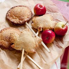 four apples and two pies on sticks