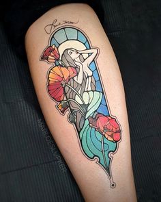 a woman's leg with a tattoo on it and flowers in the middle of her legs