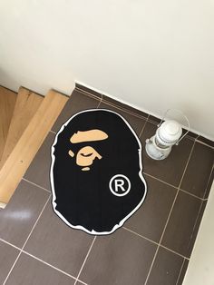 a black and white rug with a gorilla face on the floor next to a water bottle