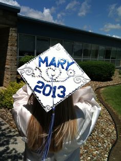 a woman wearing a white graduation cap with the word mary 2013 on it's side