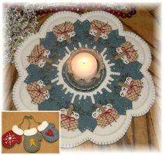 a candle is sitting on top of a doily decorated with christmas decorations and snowmen