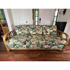 a couch sitting on top of a hard wood floor next to a white door in a living room