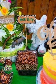 a table topped with lots of cakes and desserts covered in animal themed food items