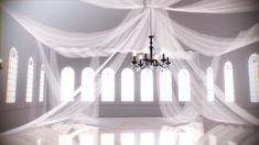 a chandelier hanging from the ceiling in front of two windows with sheer curtains