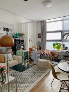 a living room filled with lots of furniture and decor on top of a hard wood floor