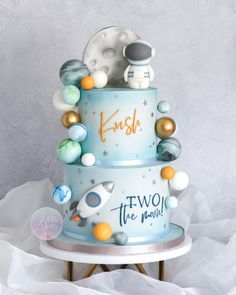 a three tiered cake decorated with planets and stars