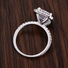 a diamond ring sitting on top of a wooden table