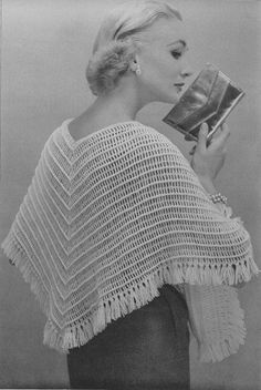 a woman wearing a shawl and holding a book