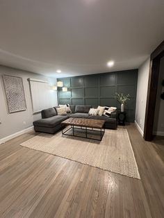 a living room with hard wood floors and gray walls