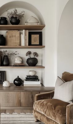 a living room filled with furniture and bookshelves next to a wall mounted shelf