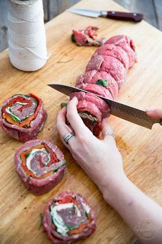 a person is cutting up some food on a wooden board