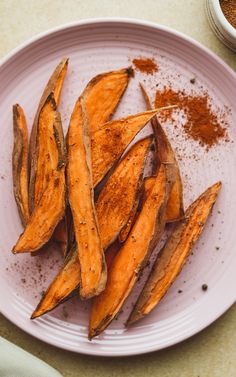 baked sweet potato wedges on a plate with seasoning