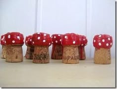 four small red mushrooms sitting on top of cork