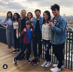 a group of people standing next to each other on a balcony