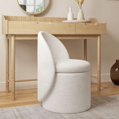 a white chair sitting in front of a table with a mirror and vase on it