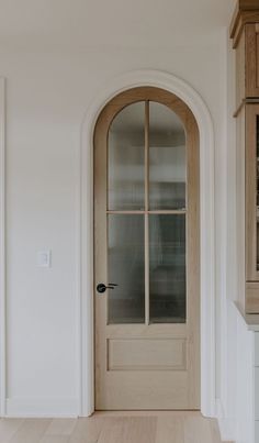 an empty entryway with a wooden door and glass front door on the right side