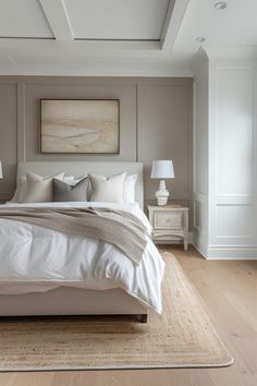 a large white bed sitting in a bedroom on top of a hard wood floor