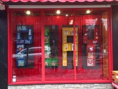 a store front with red awnings and yellow boxes on the outside, in front of it