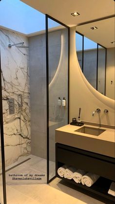 a bathroom with a sink, mirror and shower stall