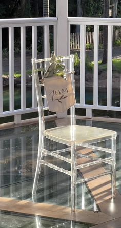 a plastic chair with a note attached to it sitting on top of a wooden deck