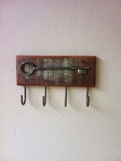 there is a clock on the wall with four hooks hanging from it's sides