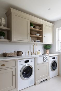 a washer and dryer sitting in a kitchen next to each other on top of cabinets