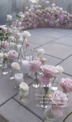 there are many vases filled with flowers on the table and candles in front of them