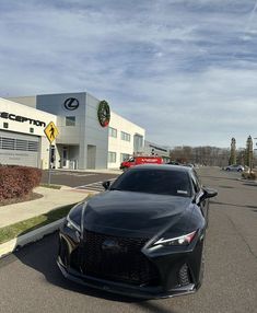 a black sports car parked in front of a toyota dealership with other cars behind it