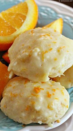 three oranges and two biscuits on a blue plate with white trim around the edges