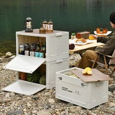 a man sitting in a chair next to a table with food and drinks on it