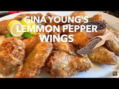 a white plate topped with chicken wings covered in lemon