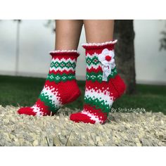 a woman's legs wearing red and green knitted christmas socks with white flowers