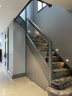 the stairs in this modern house are made of glass and steel, with lights on either side