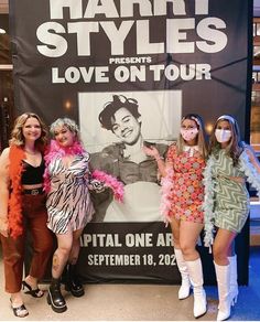 three women standing in front of a poster for harty style presents love on tour