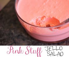 a pink stuff in a glass bowl with a spoon sticking out of the top and text overlay that reads, pink stuff jello salad