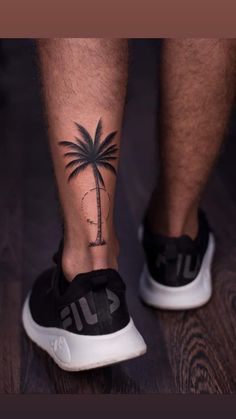 a man's foot with a palm tree tattoo on his left calf and the word surf written in black ink