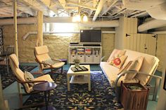 a living room filled with furniture and a flat screen tv on top of a wooden stand