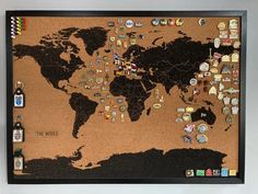 a cork board with pins and magnets attached to the map of the world on it