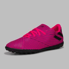 the pink and black soccer shoe is on a gray background, it's very comfortable