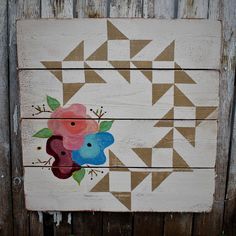 a wooden sign with flowers painted on it