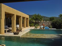 an outdoor swimming pool surrounded by lounge chairs