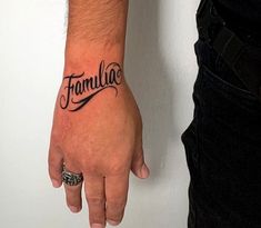 a man with a tattoo on his wrist that says famillo in cursive writing