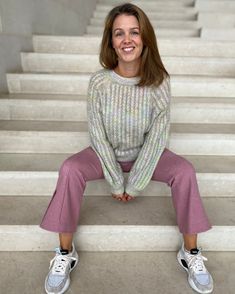 a woman is sitting on some steps smiling