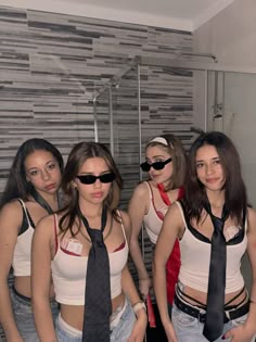 four young women are standing in the bathroom wearing neck ties and sun glasses on their heads