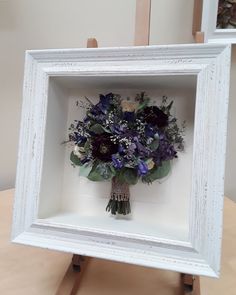 a white frame holding a bouquet of flowers