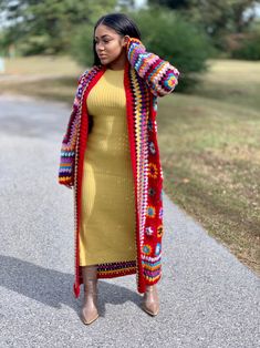 a woman in a yellow dress and colorful cardigan