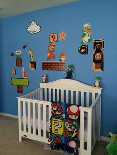 a baby's room decorated in blue and white with mario bros wall decals