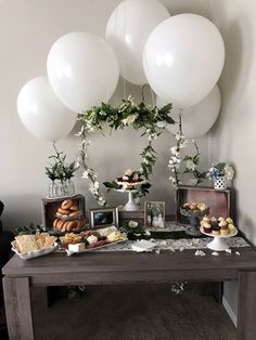 a table topped with white balloons and desserts