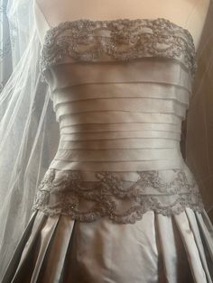 a wedding dress is displayed on a mannequin